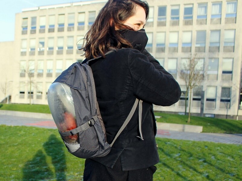 Une jeune femme porte un masque lié à un sac à dos dans lequel se trouve un système de purification d’air à base de plantes, le 18 janvier 2016 à Delft, près de La Haye © Marnix de Kroon/AFP Handout